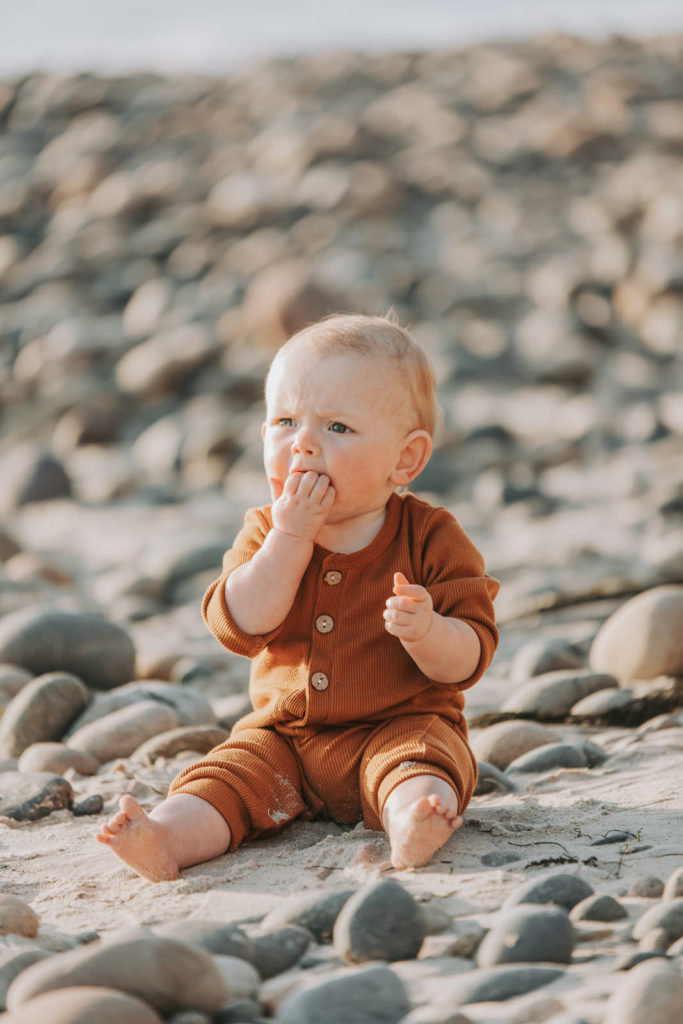 baby eating sand at lifestyle beach photoshoot 