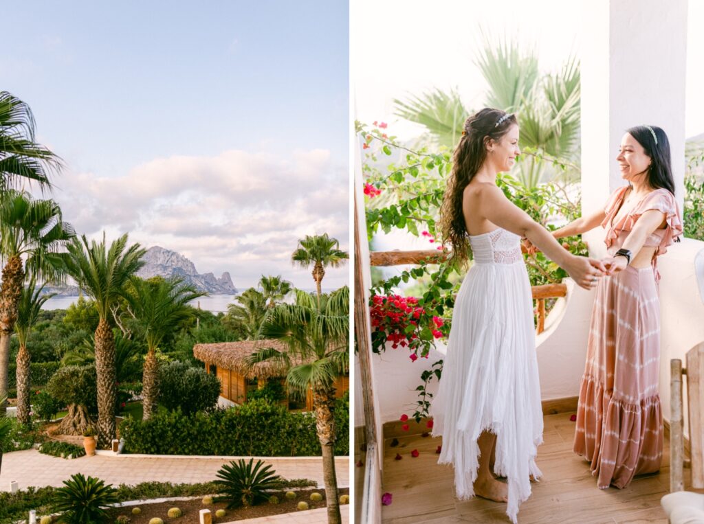 The bride and her bridesmaid embracing on the balcony, sharing a heartfelt moment, with the iconic Es Vedra peeking out from behind the cabanas and palm trees in the background, beautifully captured by Jenni Summer Studios